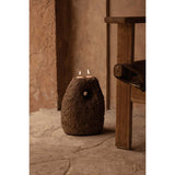 Rustic stone candle holder with two lit candles in a warm-toned room.