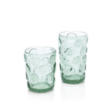 Two green glass tumblers with textured design on a white background